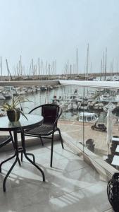 a table and chair on a balcony with a marina at RAG Marine Winner - Lovely Sea Front luxury in Herzliya B