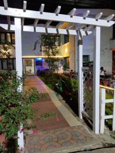 uma pérgola branca em frente a um edifício em Hotel Seven Roads em Kodaikanal