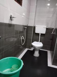 a bathroom with a toilet and a green tub at Hotel Seven Roads in Kodaikānāl