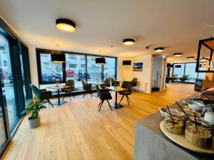 a large room with tables and chairs and windows at Creo München Süd in Munich