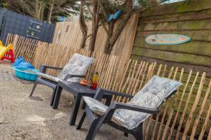 2 chaises et une table en face d'une clôture dans l'établissement BeachHouse Oase aan Zee, à Noordwijk