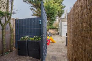 a garden with two planters next to a fence at BeachHouse Oase aan Zee in Noordwijk