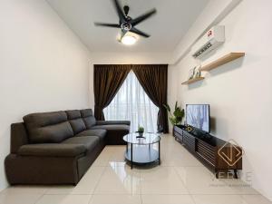 a living room with a couch and a tv at Ipoh Cove Premium Suites by Verve in Ipoh