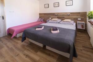 2 letti in una camera da letto con lenzuola rosa e grigie di Ubytování U Vávrů a Jižná