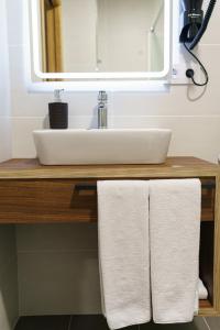 a bathroom counter with a sink and two towels at PENSIÓN CASA ELENA *** in Arzúa