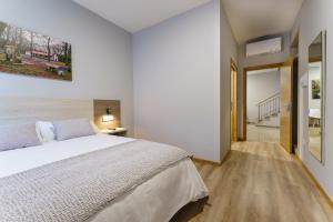 a white bedroom with a bed and a hallway at PENSIÓN CASA ELENA *** in Arzúa