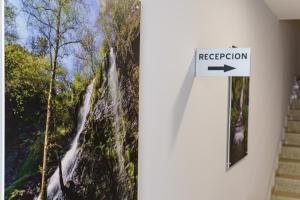 a picture of a waterfall on a wall with a sign at PENSIÓN CASA ELENA *** in Arzúa