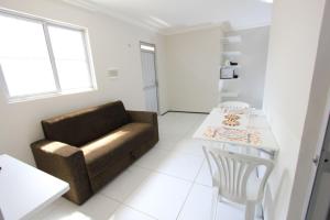 een woonkamer met een bank en een tafel bij Residencial Santa Lucia in Fortaleza