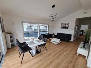 een woonkamer met een tafel en stoelen en een bank bij Panorama Penthouse in Füssen