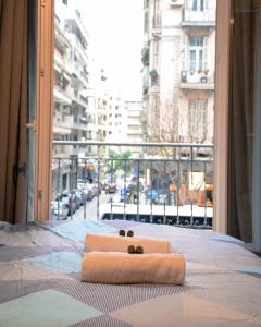 łóżko z dwoma ręcznikami na nim przed oknem w obiekcie Closer "Egnatia Apartment 2" w Salonikach