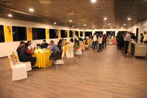 um grupo de pessoas sentadas à mesa numa sala em The Royal Palace Hotel 400703 em Navi Mumbai