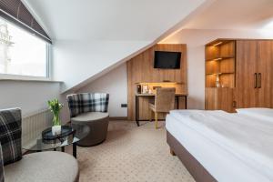 ein Hotelzimmer mit einem Bett und einem Schreibtisch in der Unterkunft Göbel's Sophien Hotel in Eisenach