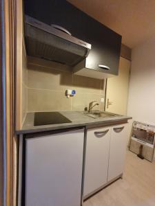 Appartement Combes Blanche 2 في مانيجود: مطبخ مع مغسلة وموقد