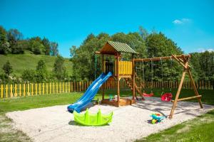 a playground with a slide and a swing at Róża Sudetów Apartamenty in Duszniki Zdrój