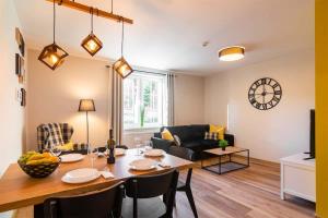 een eetkamer en woonkamer met een tafel en stoelen bij Róża Sudetów Apartamenty in Duszniki Zdrój
