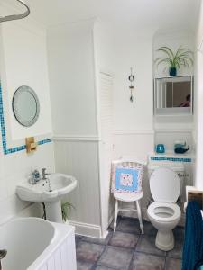 a white bathroom with a toilet and a sink at “The Reach” Lovely 2 bed house in Gorleston on Sea in Gorleston-on-Sea