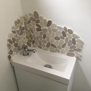 a bathroom sink with a rock wall above it at “The Reach” Lovely 2 bed house in Gorleston on Sea in Gorleston-on-Sea