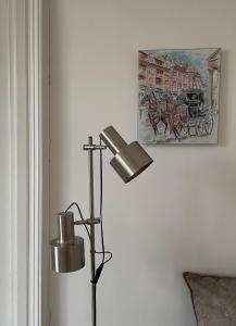 a lamp in a room with a picture on the wall at Apartment Milijana in Subotica