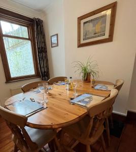 a large wooden table with chairs and glasses on it at “The Reach” Lovely 2 bed house in Gorleston on Sea in Gorleston-on-Sea