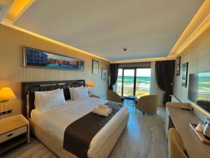 MQ Hotel Suites في Arnavutköy: غرفة الفندق بسرير كبير ومكتب