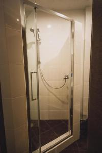 a shower with a glass door in a bathroom at Kvartira Klassika na Prospekte Kultury 11 in Omsk