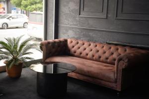 a brown couch sitting in a room with a table at Aura Boutique Hotel in Batumi