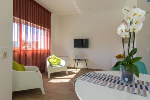 un soggiorno con un vaso di fiori su un tavolo di Suite du Parc & Hotel a Giulianova