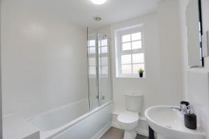 a white bathroom with a toilet and a sink at STALDON COURT - Open Plan Apartment, High Speed Wi-Fi, Free Parking in Swindon
