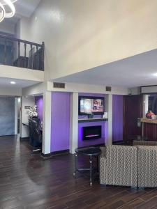 een woonkamer met paarse muren en een bank bij Baymont by Wyndham Bellevue - Omaha in Bellevue