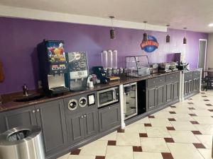 a kitchen with purple walls and a tv on a counter at Baymont by Wyndham Bellevue - Omaha in Bellevue