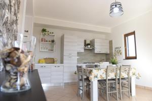 a kitchen with white cabinets and a kitchen island with stools at Fornillo 41 in Poggiomarino