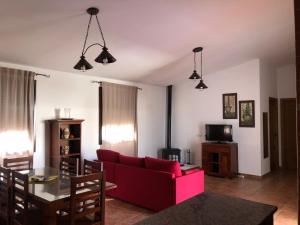 sala de estar con sofá rojo y mesa en Chalet Ventura en Conil en Conil de la Frontera