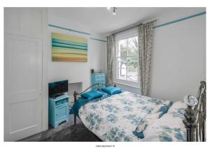 a bedroom with a bed and a tv and a window at The Park Apartment in Haywards Heath