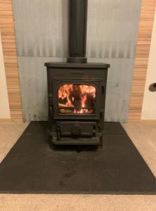 a stove in a room with a fire in it at Squirrel Lodge (Unit 7) in Carlisle