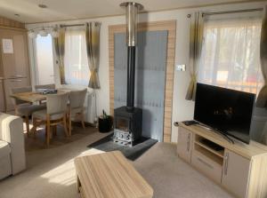 uma sala de estar com um fogão e uma mesa de jantar em Squirrel Lodge (Unit 7) em Carlisle