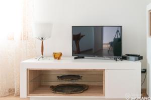 een tv op de top van een wit entertainment center bij The VIEW Apartment, MURANO island in Murano