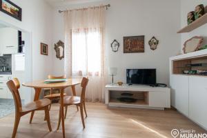 uma sala de estar com uma mesa e uma televisão em The VIEW Apartment, MURANO island em Murano