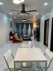 a living room with a white table and chairs at Spanish Villa homestay in Senawang