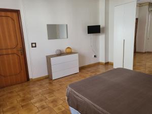 - une chambre avec un lit, une commode et un miroir dans l'établissement Bilo Cisaria, à Porto Cesareo