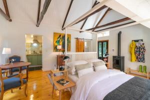 a bedroom with a bed and a desk and a table at Ganzvlei Manor Cottage in Knysna