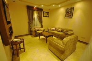 a living room with a couch and a table at Kinda Suites in Taif