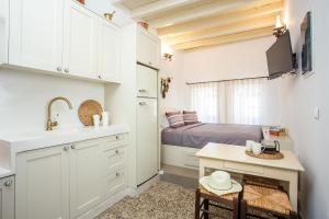 a kitchen with a sink and a bed in a room at Heritage Luxury Suites in Líndos