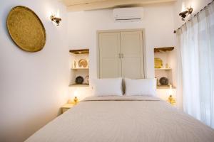 a bedroom with a large bed with two pillows at Heritage Luxury Suites in Lindos