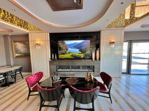 een woonkamer met een tafel en stoelen en een televisie bij MQ Hotel Suites in Arnavutköy