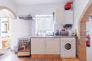 a kitchen with a stove and a washing machine at Casa Oceano-Ave do Mar in Raposeira