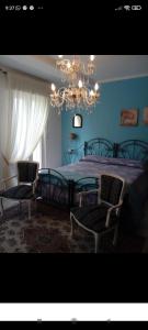 1 dormitorio con 1 cama con 2 sillas y una lámpara de araña en Villa Lucia Anna, en Scalo dei Saraceni Manfredonia