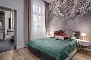 ein Schlafzimmer mit einem Bett mit einer grünen Bettdecke in der Unterkunft Apartament biały z jacuzzi in Krakau