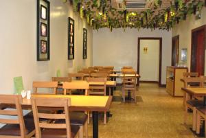 a restaurant with wooden tables and chairs in a room at Dragon Home Inn in Cebu City