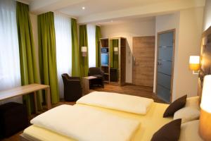 a hotel room with two beds and a desk at Der Patrizierhof - Weingut Gasthof Hotel - Familie Grebner in Großlangheim