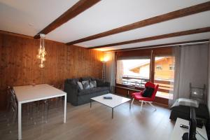 - un salon avec un canapé et une table dans l'établissement Mondzeu C261, à Bagnes